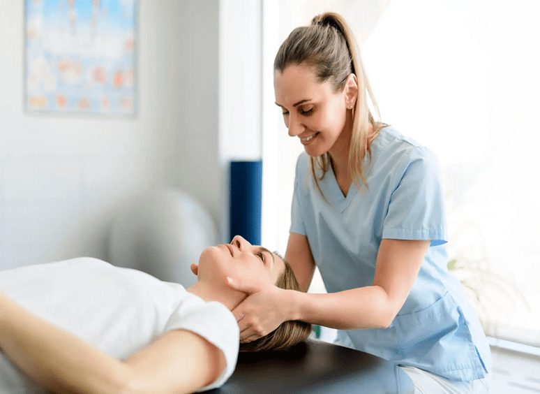 A therapist gently massages a client's neck in a calm setting.