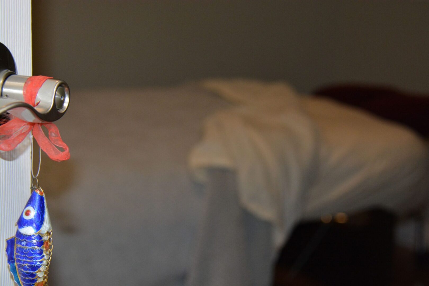 A neatly made bed with a white blanket draped over the edge.