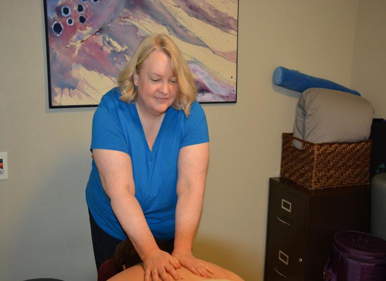 A person giving a massage in a cozy room.